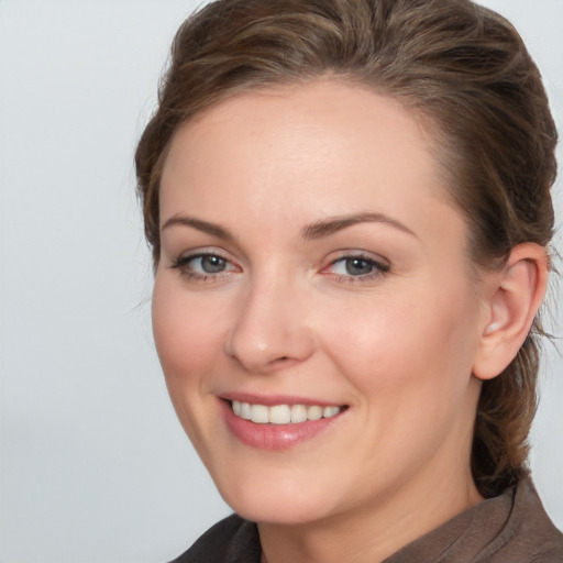 Joyful white young-adult female with medium  brown hair and grey eyes