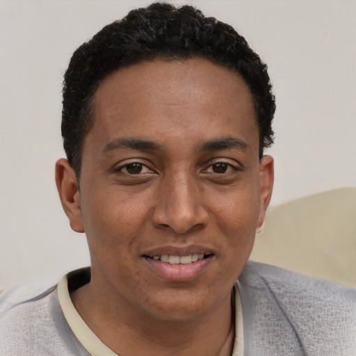 Joyful black young-adult male with short  black hair and brown eyes