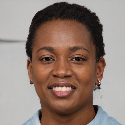 Joyful black young-adult female with short  black hair and brown eyes
