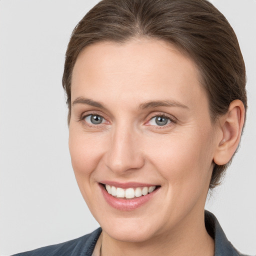 Joyful white young-adult female with medium  brown hair and grey eyes