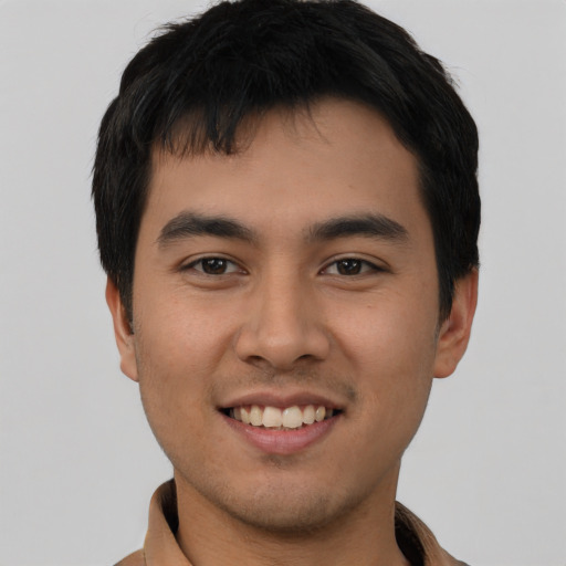 Joyful asian young-adult male with short  brown hair and brown eyes