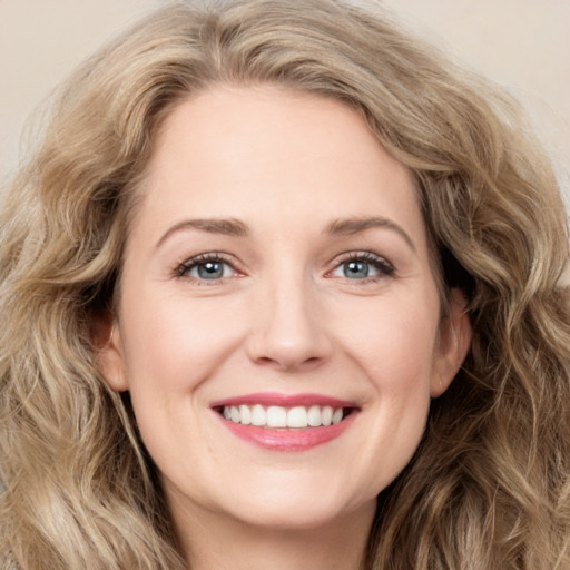 Joyful white young-adult female with long  brown hair and green eyes