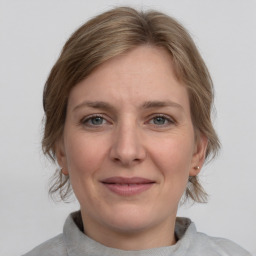 Joyful white adult female with medium  brown hair and grey eyes