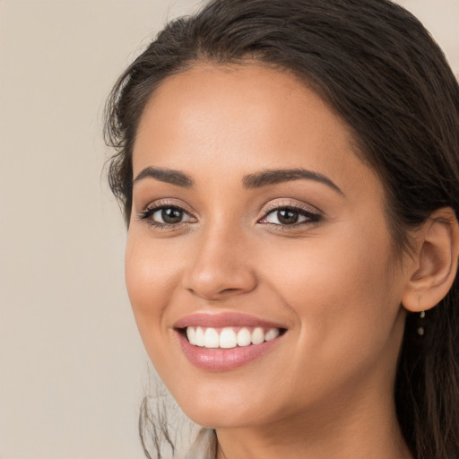 Joyful white young-adult female with long  brown hair and brown eyes