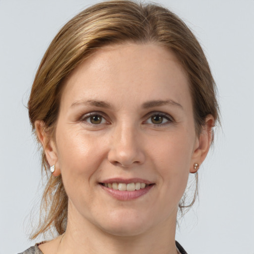 Joyful white young-adult female with medium  brown hair and grey eyes