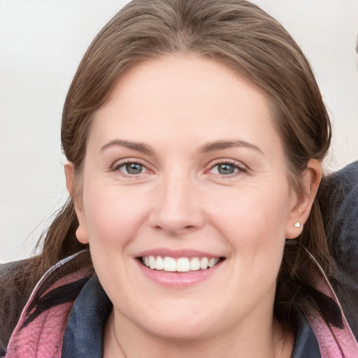 Joyful white young-adult female with medium  brown hair and grey eyes