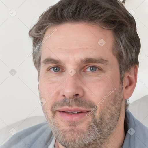 Joyful white adult male with short  brown hair and grey eyes