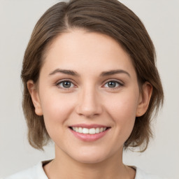 Joyful white young-adult female with medium  brown hair and green eyes