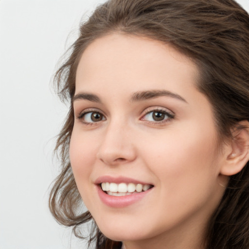 Joyful white young-adult female with long  brown hair and green eyes