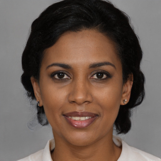 Joyful black young-adult female with medium  black hair and brown eyes