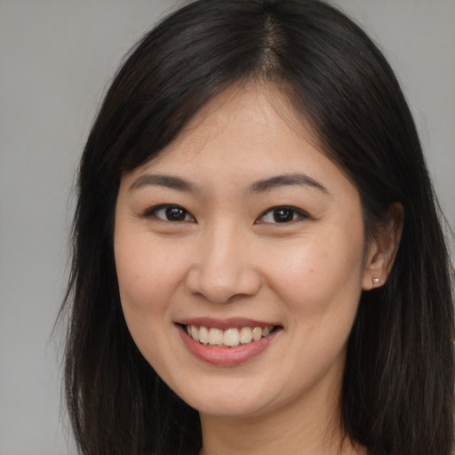 Joyful asian young-adult female with long  brown hair and brown eyes