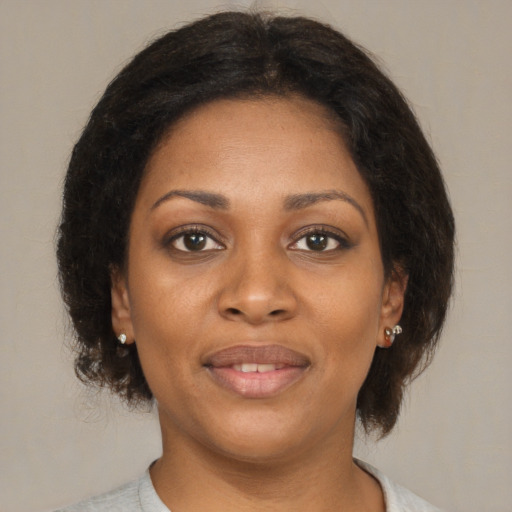 Joyful black young-adult female with medium  brown hair and brown eyes