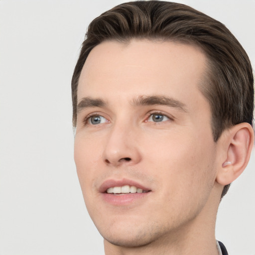 Joyful white young-adult male with short  brown hair and grey eyes