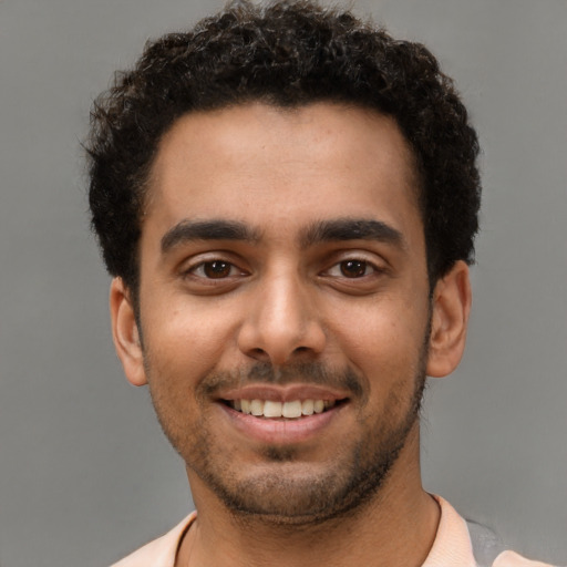Joyful latino young-adult male with short  brown hair and brown eyes