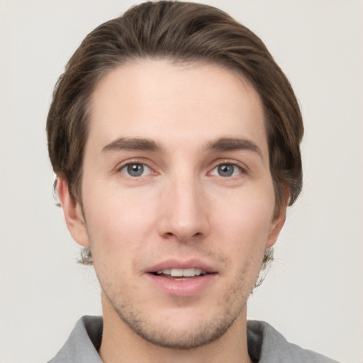 Joyful white young-adult male with short  brown hair and grey eyes