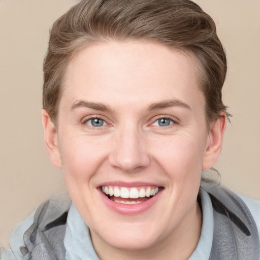 Joyful white adult female with short  brown hair and blue eyes