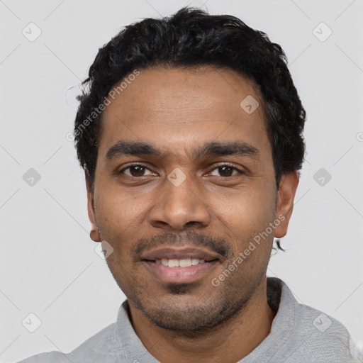 Joyful latino young-adult male with short  black hair and brown eyes