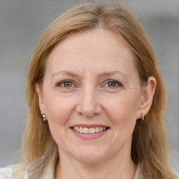 Joyful white adult female with medium  brown hair and blue eyes