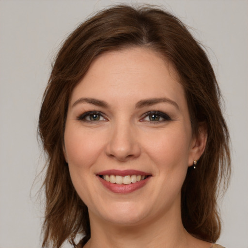 Joyful white young-adult female with medium  brown hair and green eyes