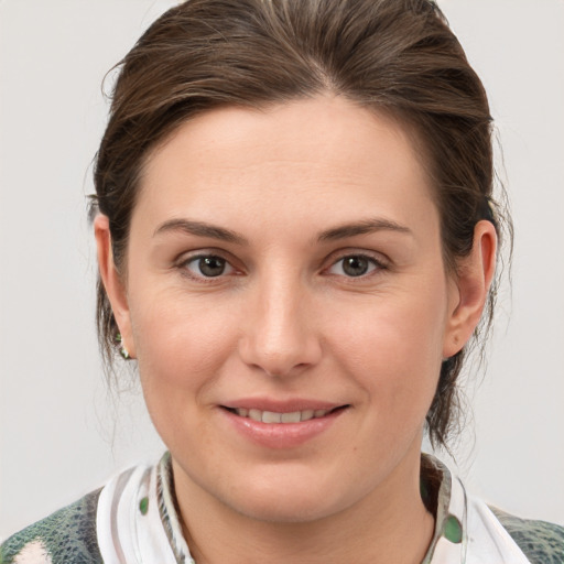 Joyful white young-adult female with medium  brown hair and grey eyes