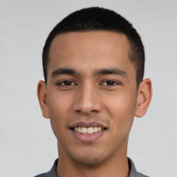 Joyful latino young-adult male with short  black hair and brown eyes