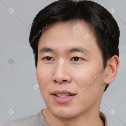 Joyful asian young-adult male with short  brown hair and brown eyes
