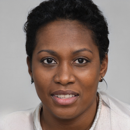 Joyful black young-adult female with short  black hair and brown eyes