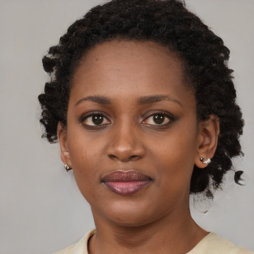 Joyful black young-adult female with medium  black hair and brown eyes