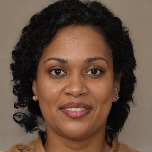Joyful black adult female with medium  brown hair and brown eyes