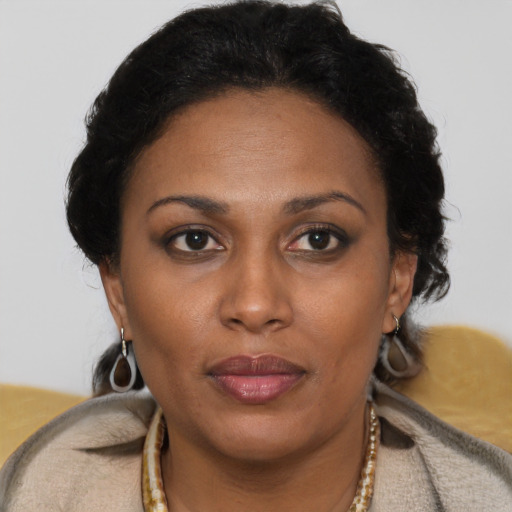 Joyful black adult female with short  brown hair and brown eyes