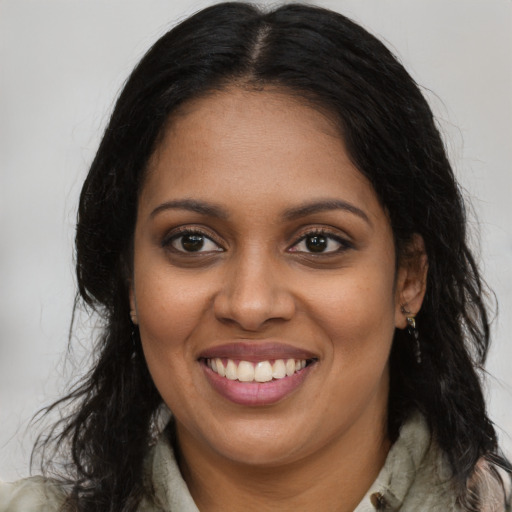 Joyful black young-adult female with long  brown hair and brown eyes
