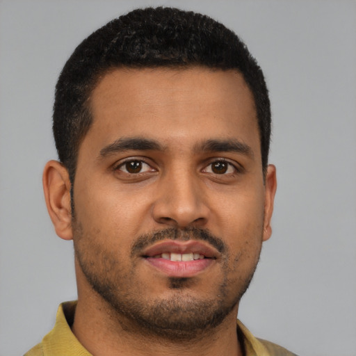 Joyful black young-adult male with short  brown hair and brown eyes