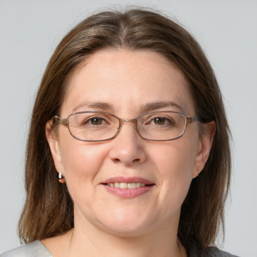 Joyful white adult female with medium  brown hair and grey eyes