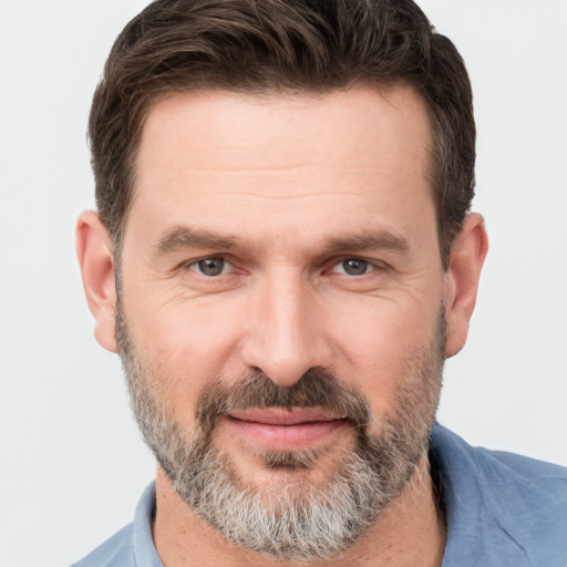 Joyful white adult male with short  brown hair and brown eyes