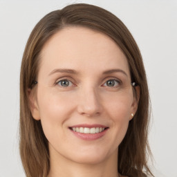 Joyful white young-adult female with long  brown hair and grey eyes