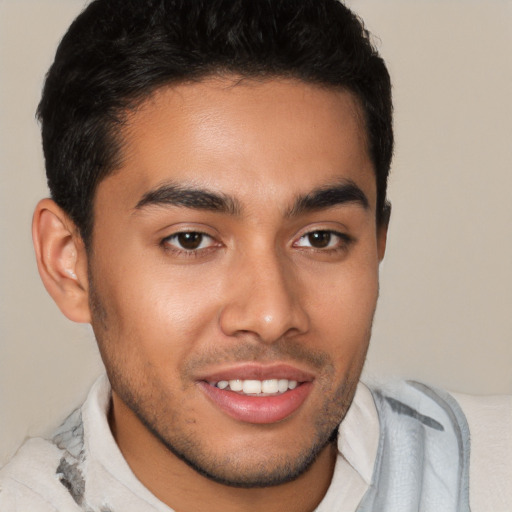 Joyful latino young-adult male with short  brown hair and brown eyes