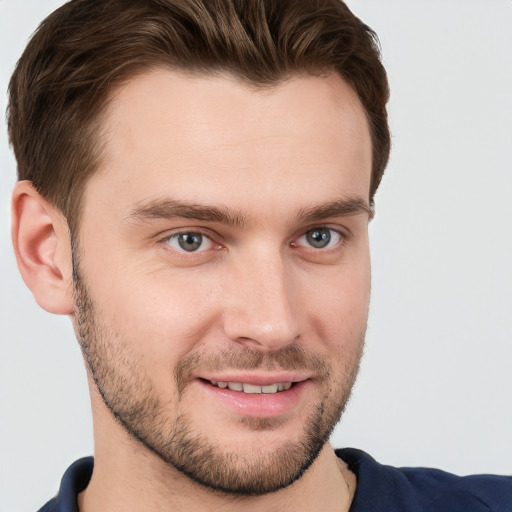 Joyful white young-adult male with short  brown hair and grey eyes