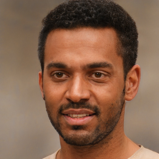 Joyful black young-adult male with short  black hair and brown eyes