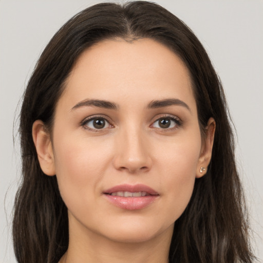 Joyful white young-adult female with long  brown hair and brown eyes