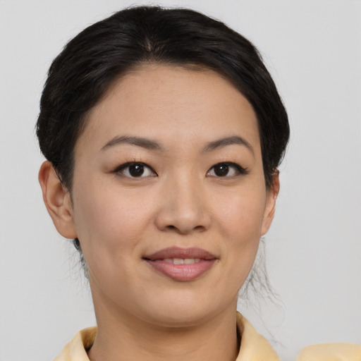 Joyful asian young-adult female with short  brown hair and brown eyes