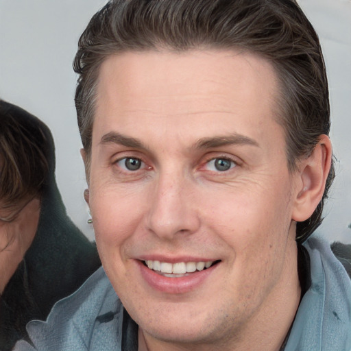 Joyful white adult male with short  brown hair and grey eyes