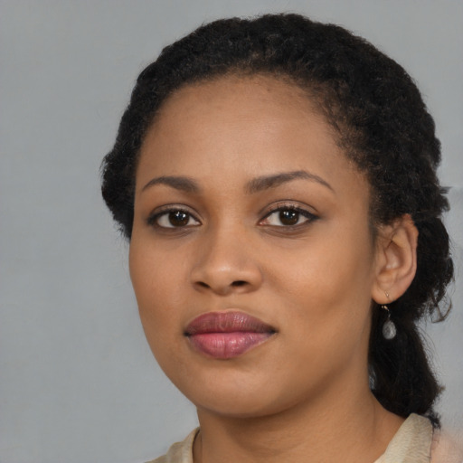 Joyful black young-adult female with long  black hair and brown eyes