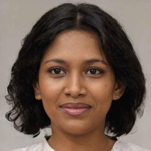 Joyful black young-adult female with medium  black hair and brown eyes