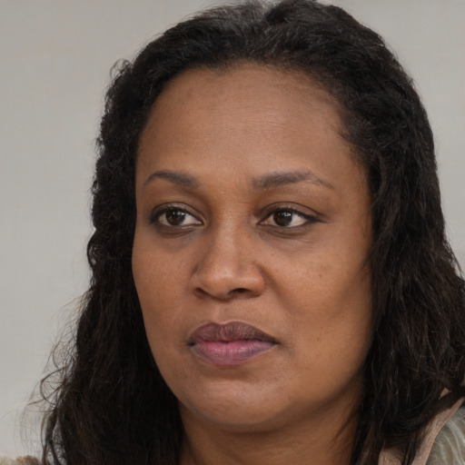Joyful black young-adult female with long  brown hair and brown eyes