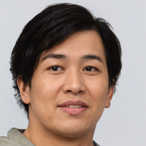 Joyful asian adult male with short  brown hair and brown eyes