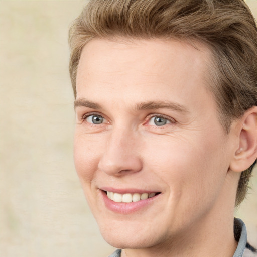 Joyful white young-adult male with medium  brown hair and grey eyes