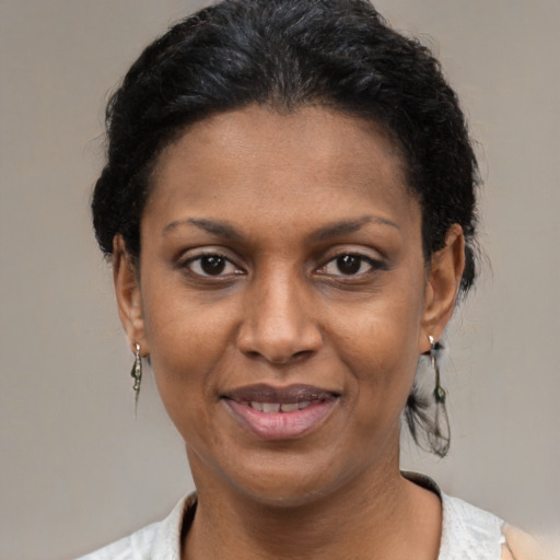 Joyful black young-adult female with short  black hair and brown eyes