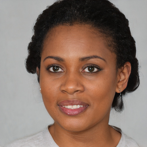 Joyful black young-adult female with short  brown hair and brown eyes