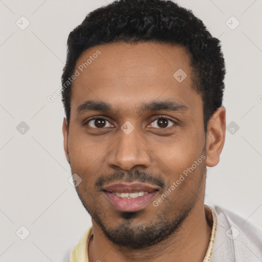 Joyful black young-adult male with short  black hair and brown eyes