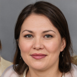 Joyful white adult female with medium  brown hair and brown eyes